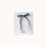 Green ribbon on a white gift bag with 'areme' branding