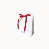 White gift box with a red ribbon and 'areme' branding on a white background